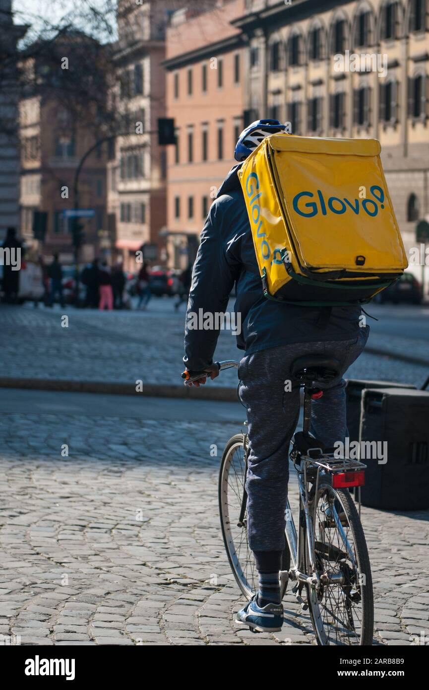 Rome, 17/01/2020: young boy glovo rider making delivery on his bike working in the so called gig economy, Esquilino square. ©Andrea Sabbadini Stock Photo