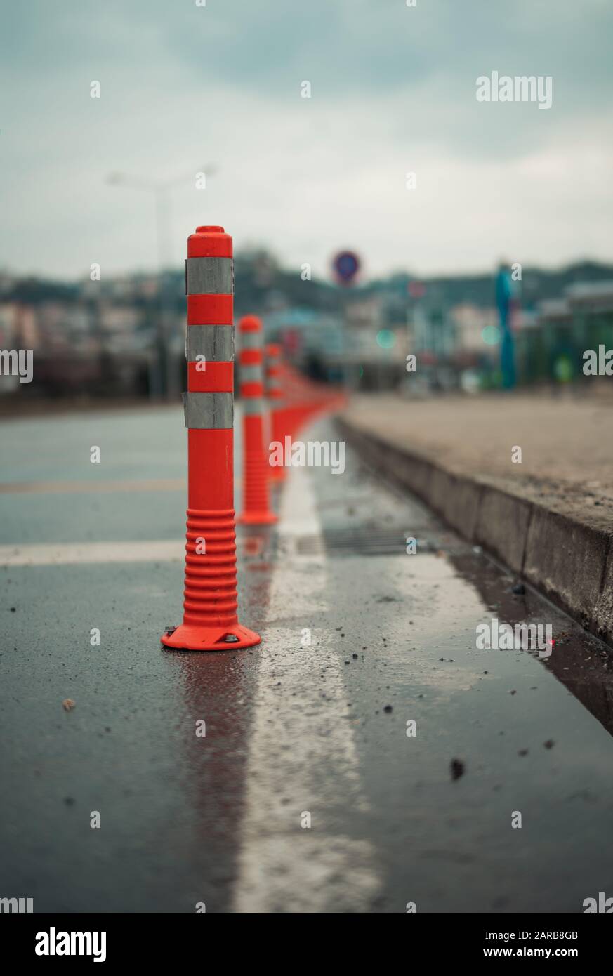 Traffic cones on an asphalt road in a cloudy weather Stock Photo