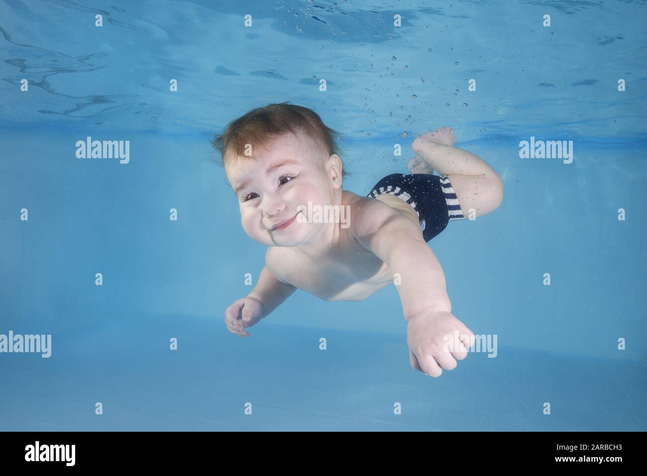 Little baby boy learns to swims underwater. Baby swimming underwater in