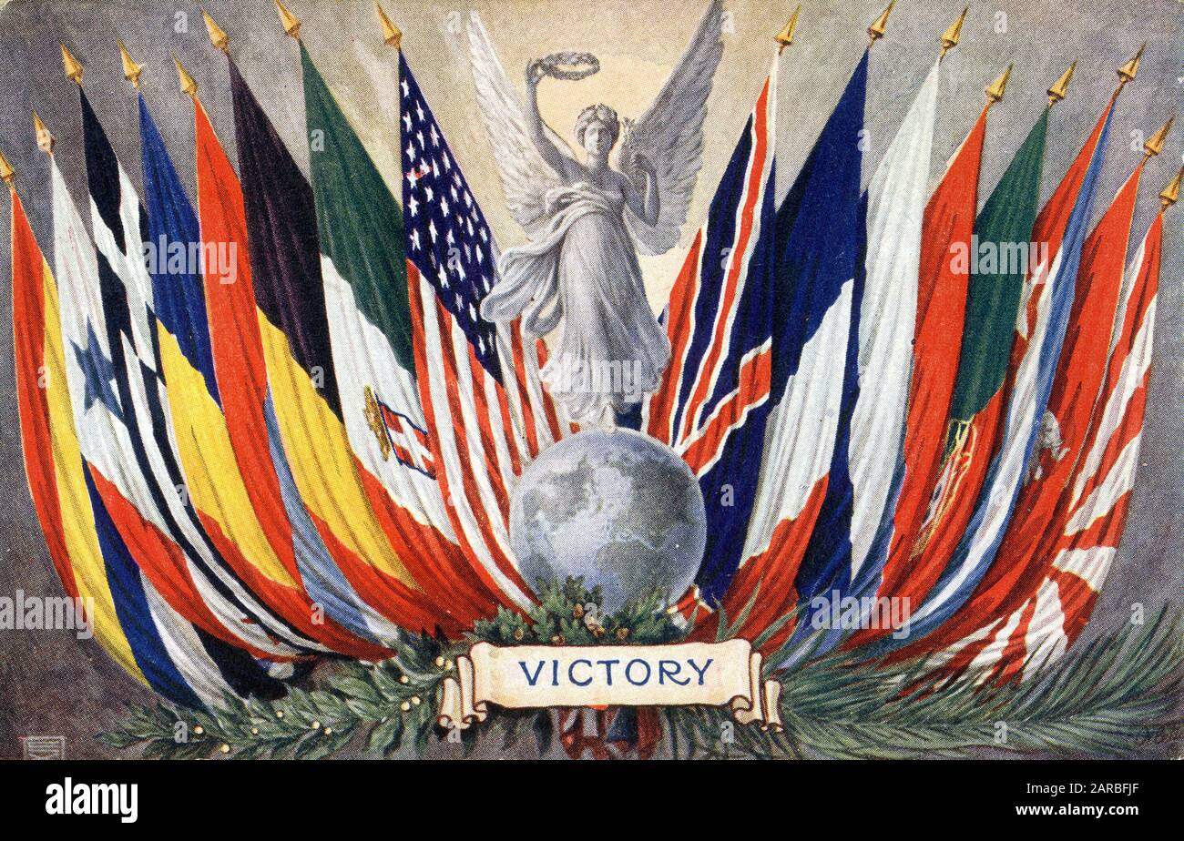 WW1 - Victory - The flags of the victorious nations flanking a carved statue of the personification of Victory stood atop the world and holding a victory wreath aloft.     Date: circa 1919 Stock Photo