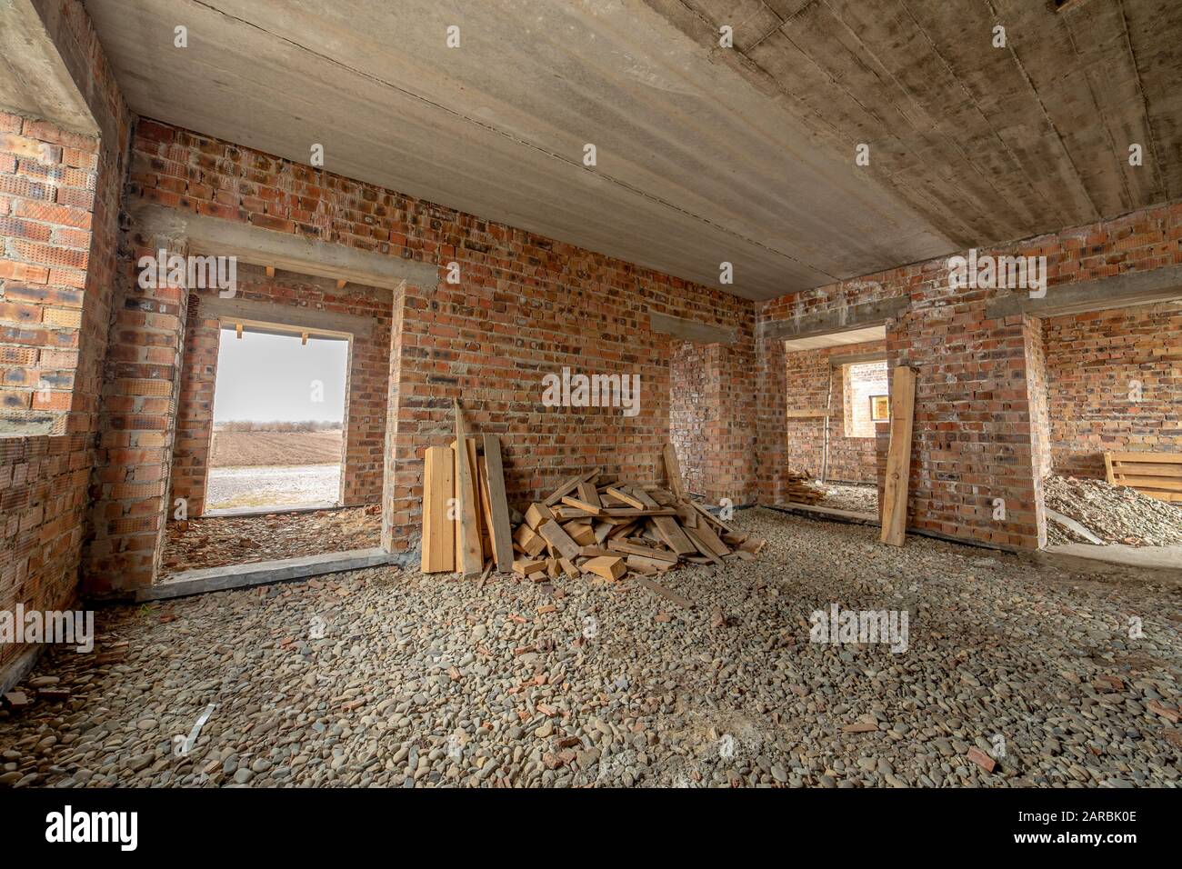 Interior Of Unfinished Brick House With Concrete Floor And Bare
