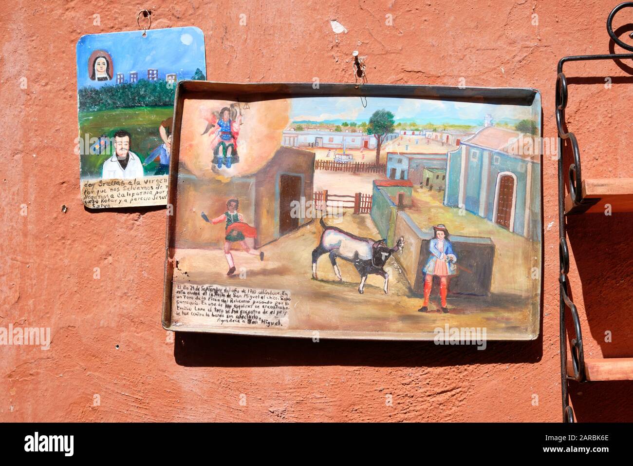 Mexican Naive art folk painting depicting 18th century rural scene, on Metal trays hanging on wall outside Stock Photo