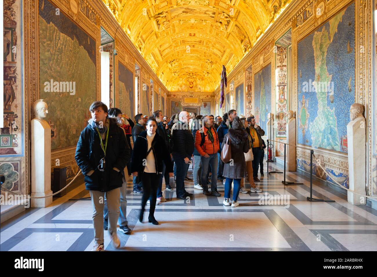 Rome, Italy - Jan 3, 2020: Wall and ceiling paintings in the Gallery of Maps with tourists wandering around at the Vatican Museum, Vatican City, Rome Stock Photo