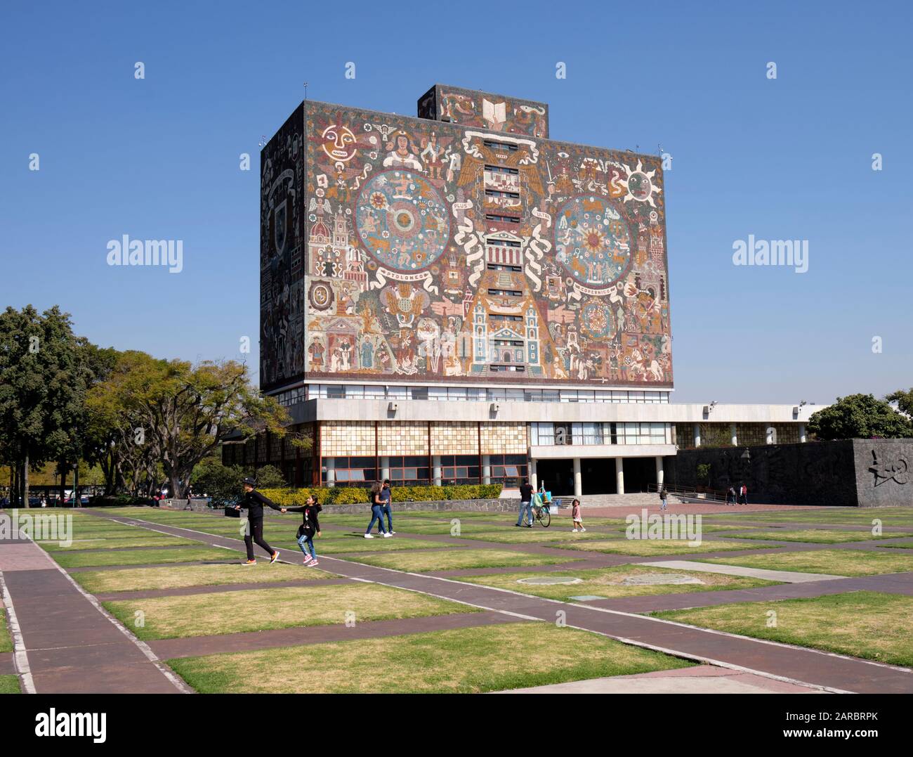Mexico city University campus library iconic facade  created by the Mexican artist Juan O'Gorman with people walking by Stock Photo