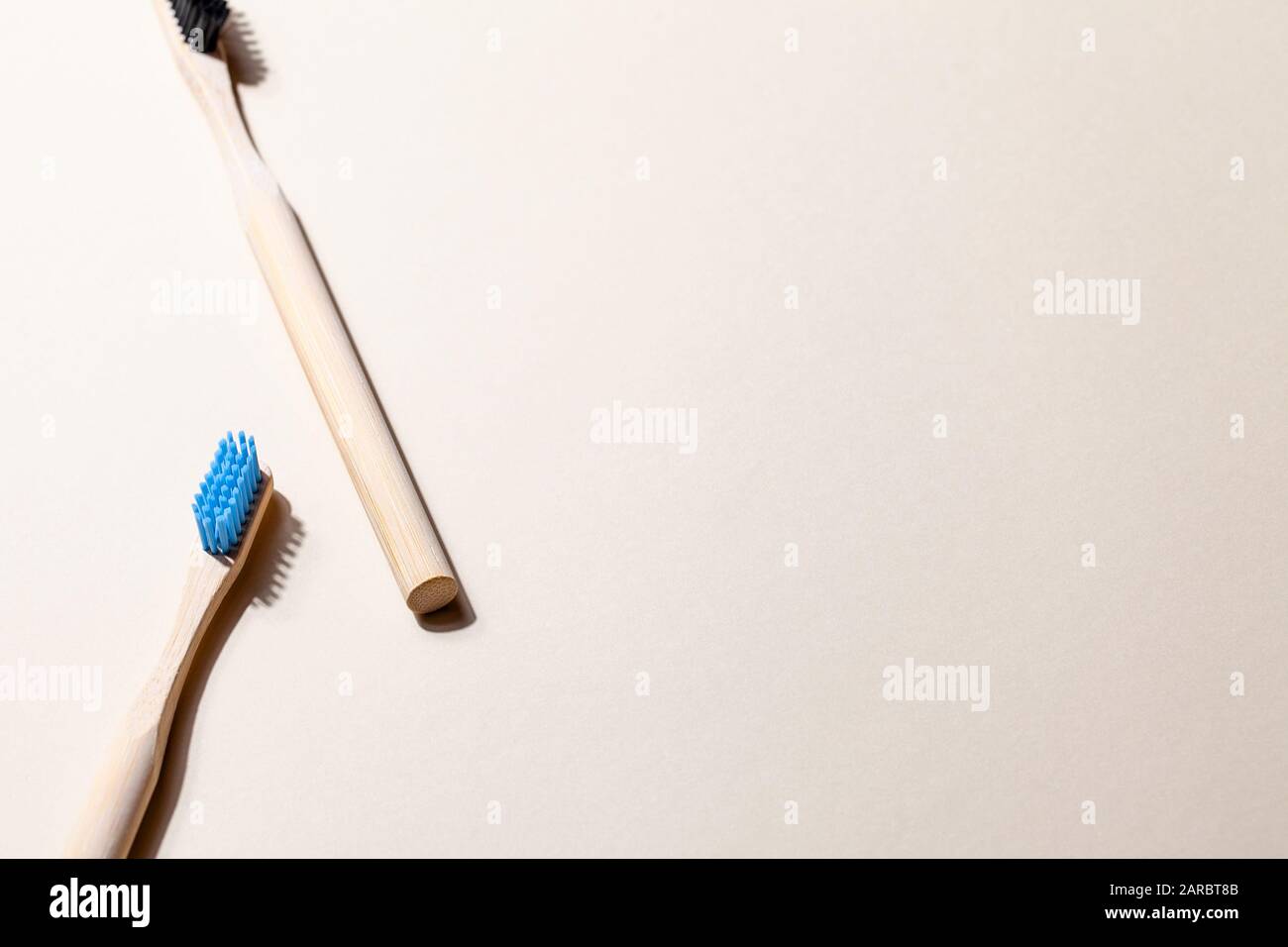 Bamboo toothbrushes on light background with shadow and copy space ...