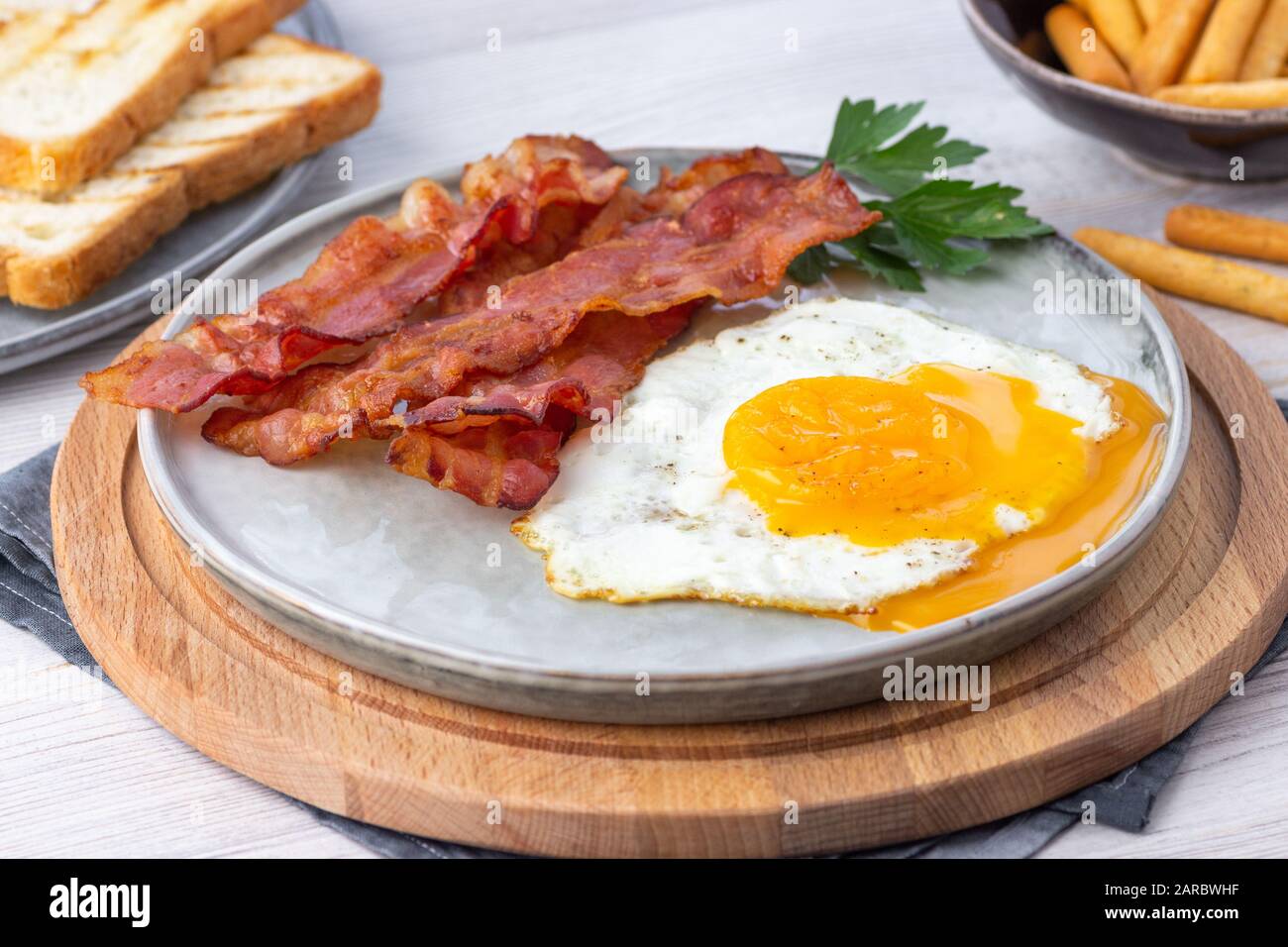 Breakfast - fried bacon pieces and eggs on a plate Stock Photo - Alamy