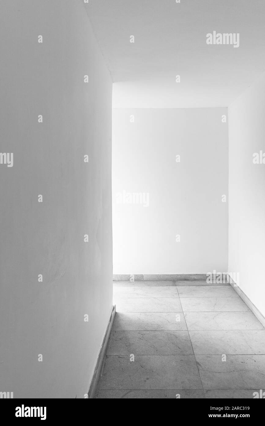 Abstract empty modern interior, vertical photo of white corridor. Black and white Stock Photo