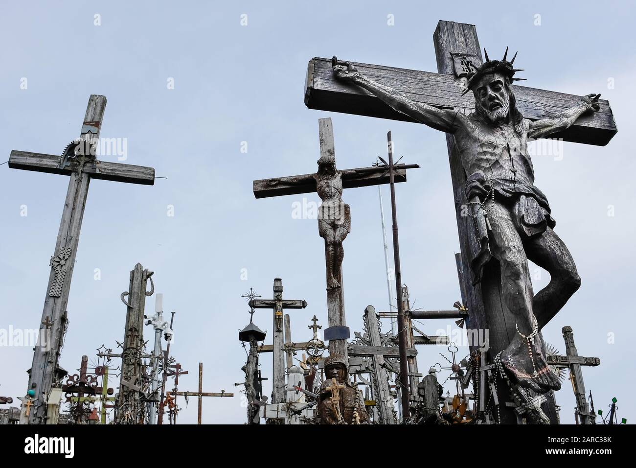 Low angle view of large carving of Jesus on cross surrounded by other wooden crosses Stock Photo