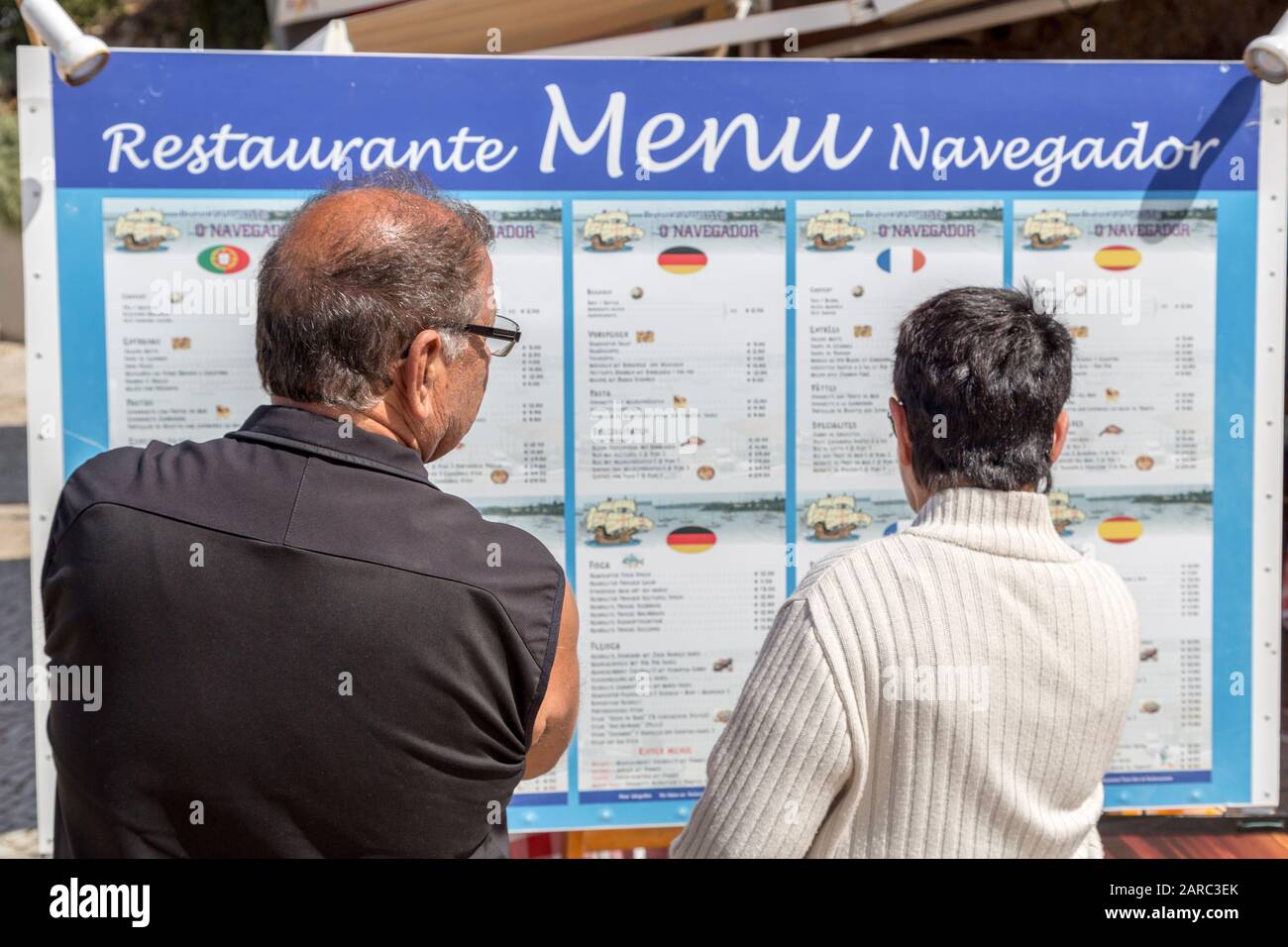 Reading menu at restaurant in different languages, Alvor, Algarve, Portugal Stock Photo