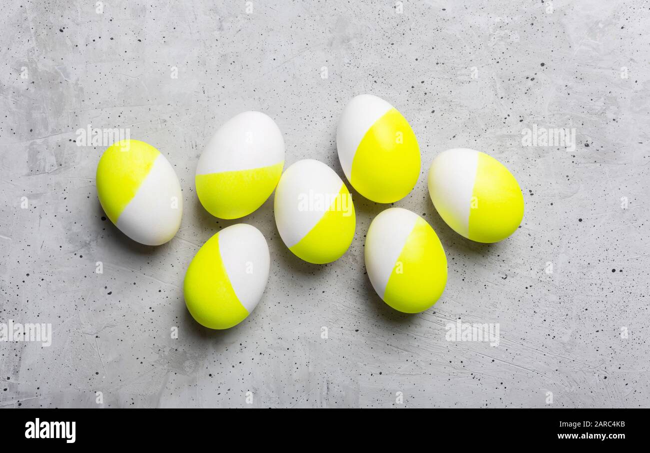 Eggs painted in white and yellow on a gray background Stock Photo