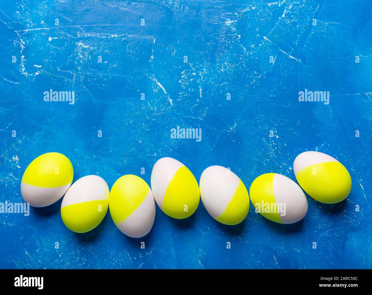 Five easter painted eggs green yellow on blue Stock Photo