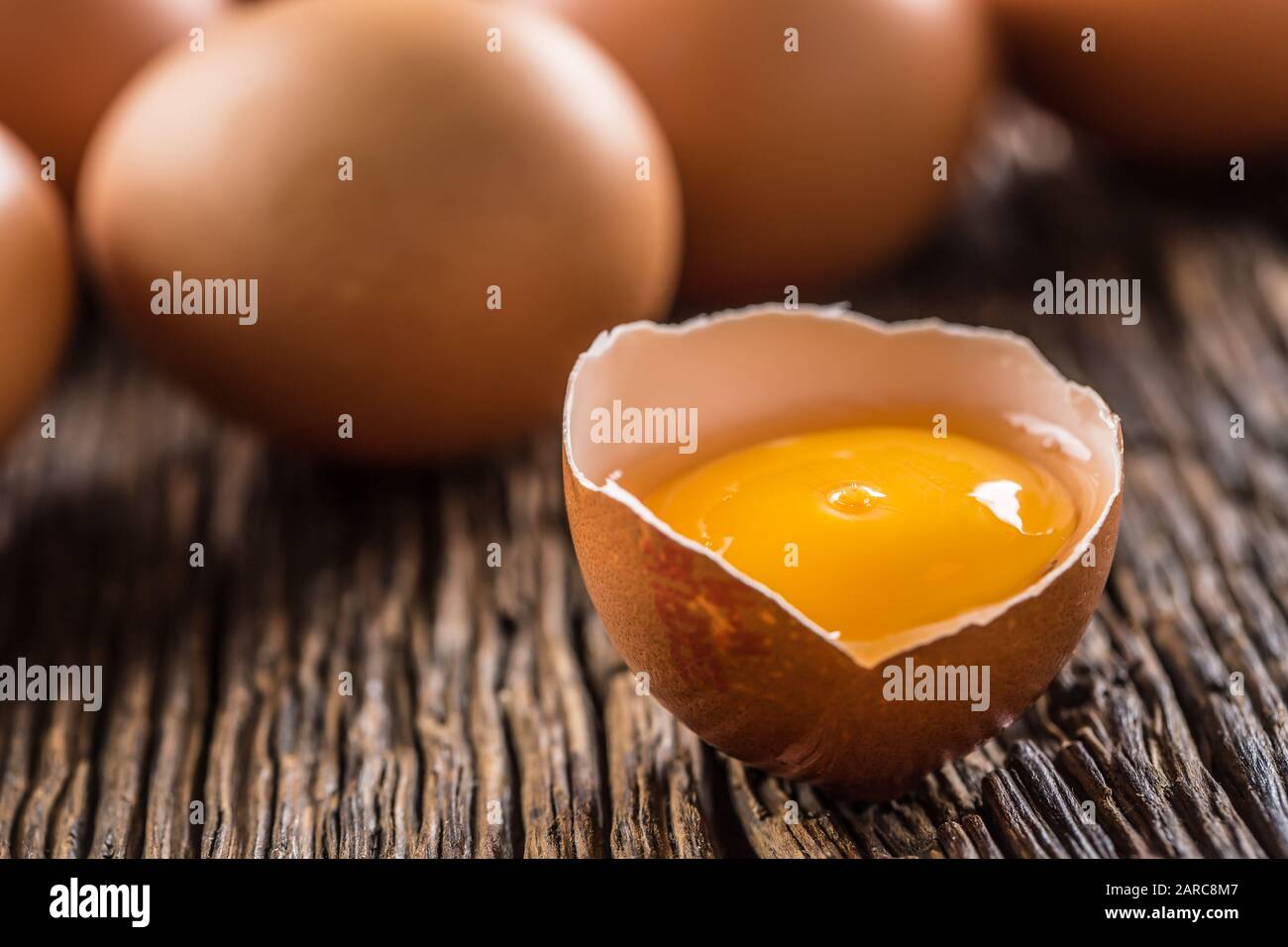 Fresh raw eggs on rustic wooden table Stock Photo