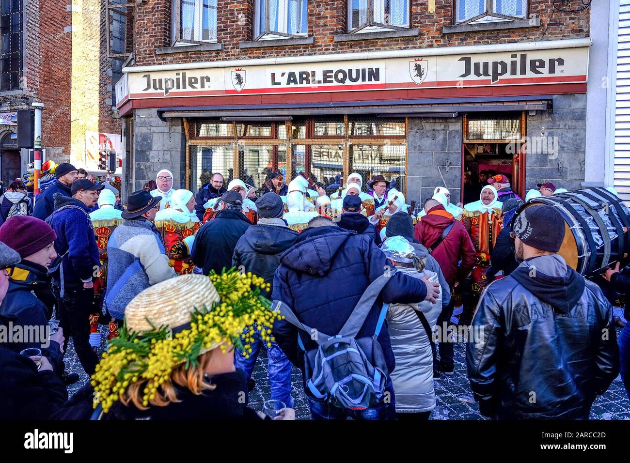 BINCHE, BELGIUM - Feb 18, 2018: Rassemblement de Gilles de Binche avec public en avant-plan montrant une participante portant un chapeau orné de mimos Stock Photo