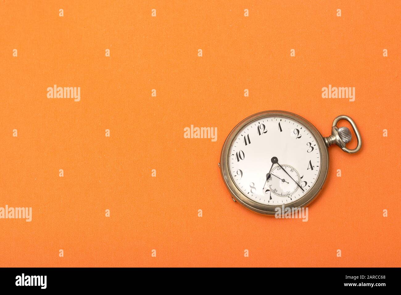 Clock on an orange surface - time management concept Stock Photo