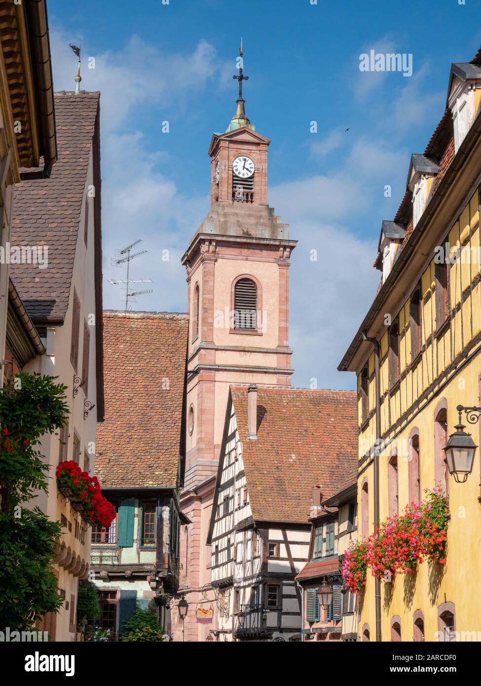 Medieval half timbered buildings and a church bell tower in Colmar Alsace France Stock Photo
