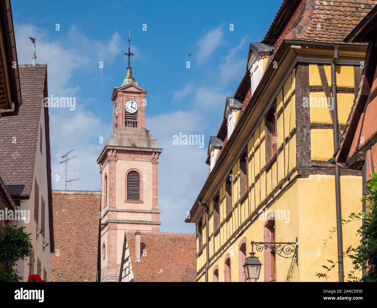 Medieval half timbered buildings and a church bell tower in Colmar Alsace France Stock Photo