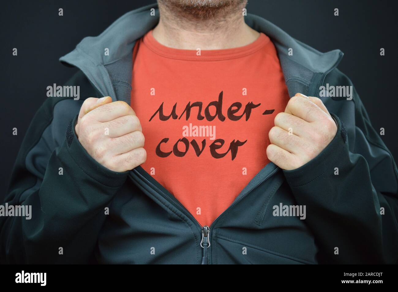 a man showing his t-shirt with the word undercover on it Stock Photo