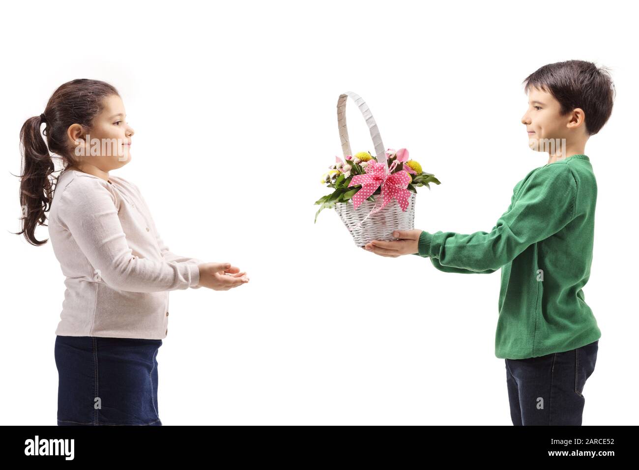 Boy giving a basket with flowers to a girl isolated on white background Stock Photo