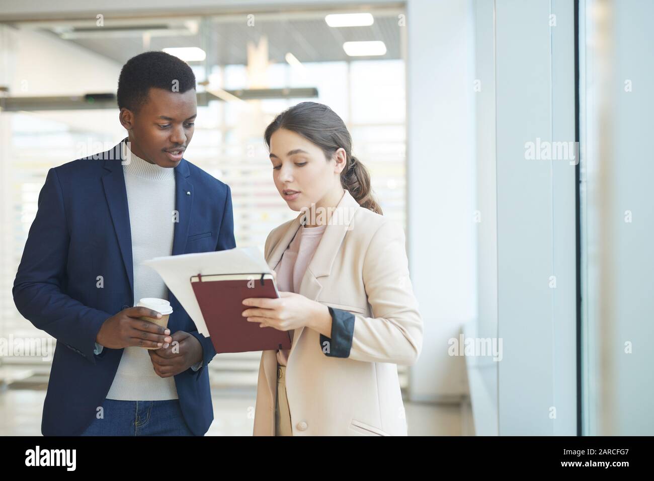 Waist up portrait of successful African businessman talking to female ...