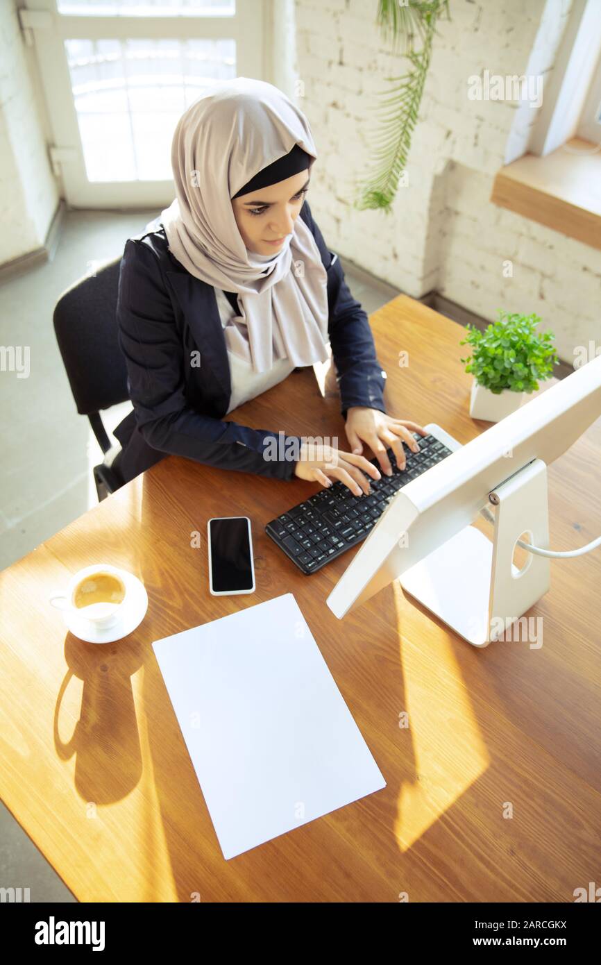 Typing text. Portrait of a beautiful arabian businesswoman wearing ...