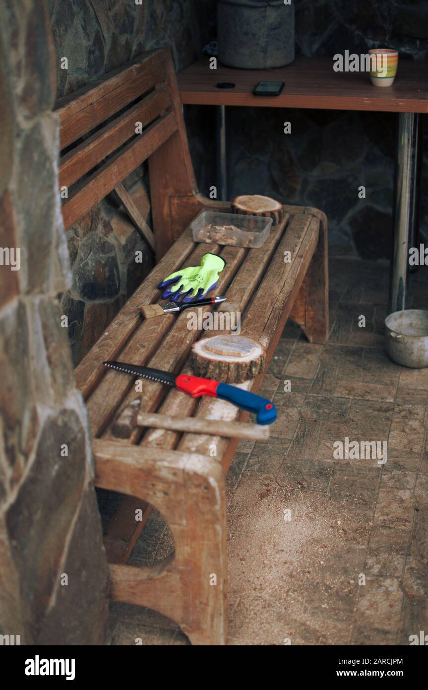 An Old Hammer A Hand Saw Protective Gloves And A Round Pine Beam