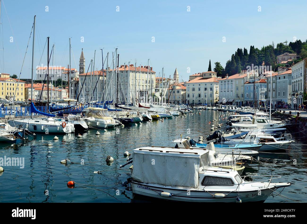 Piran, Slovenia - July 4th 2015: Unidentified people, harbor, boats, buildings and campanile in the pictoresque village on Adriatic sea Stock Photo