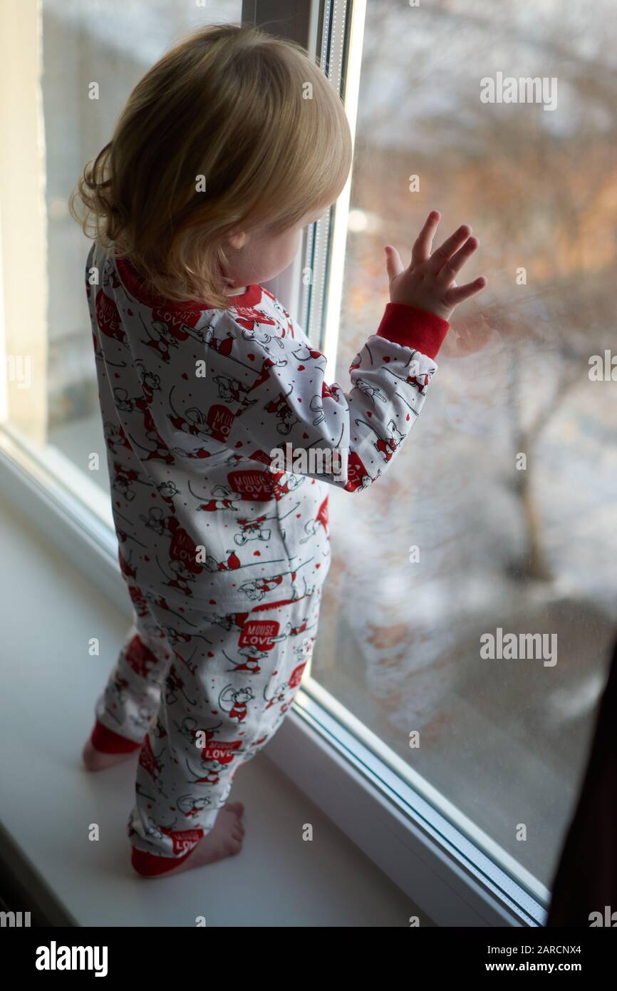 A little girl standing in front of a window Stock Photo - Alamy