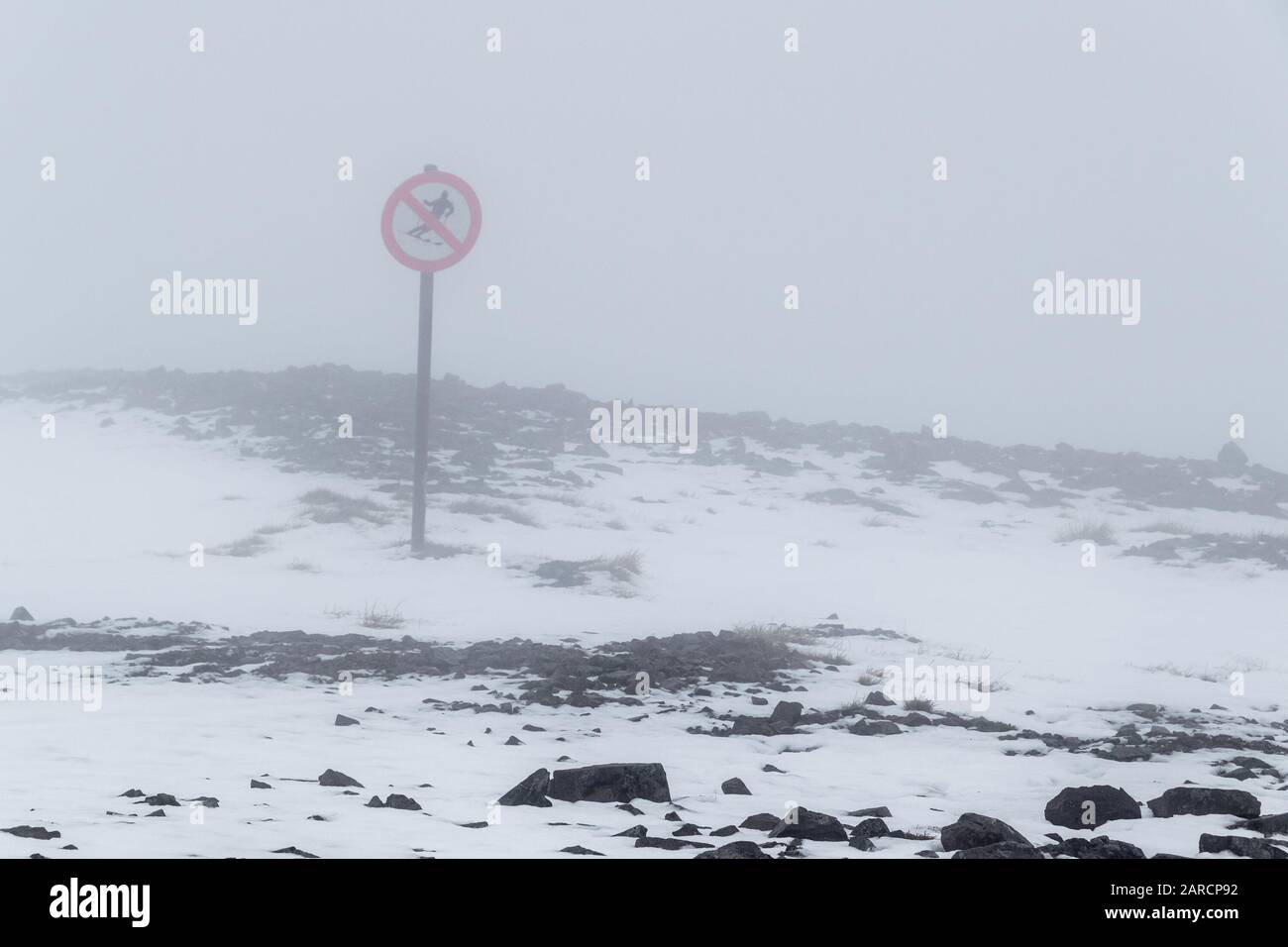 Red 'No skiing' sign in deep fog on an empty ski piste in Glen Coe, Scotland. Stock Photo