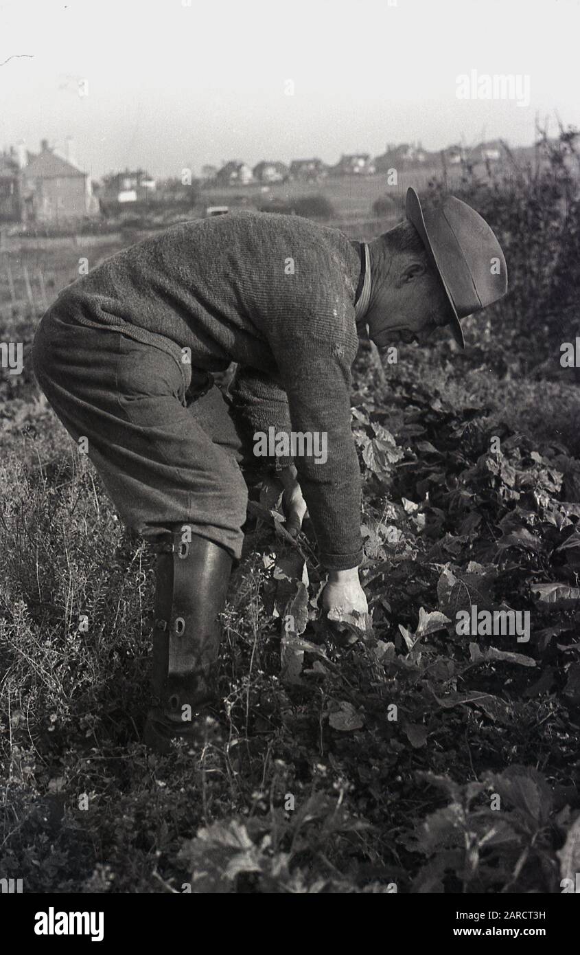 1950s, historical, man in boots and hat outside in a corner of a rural