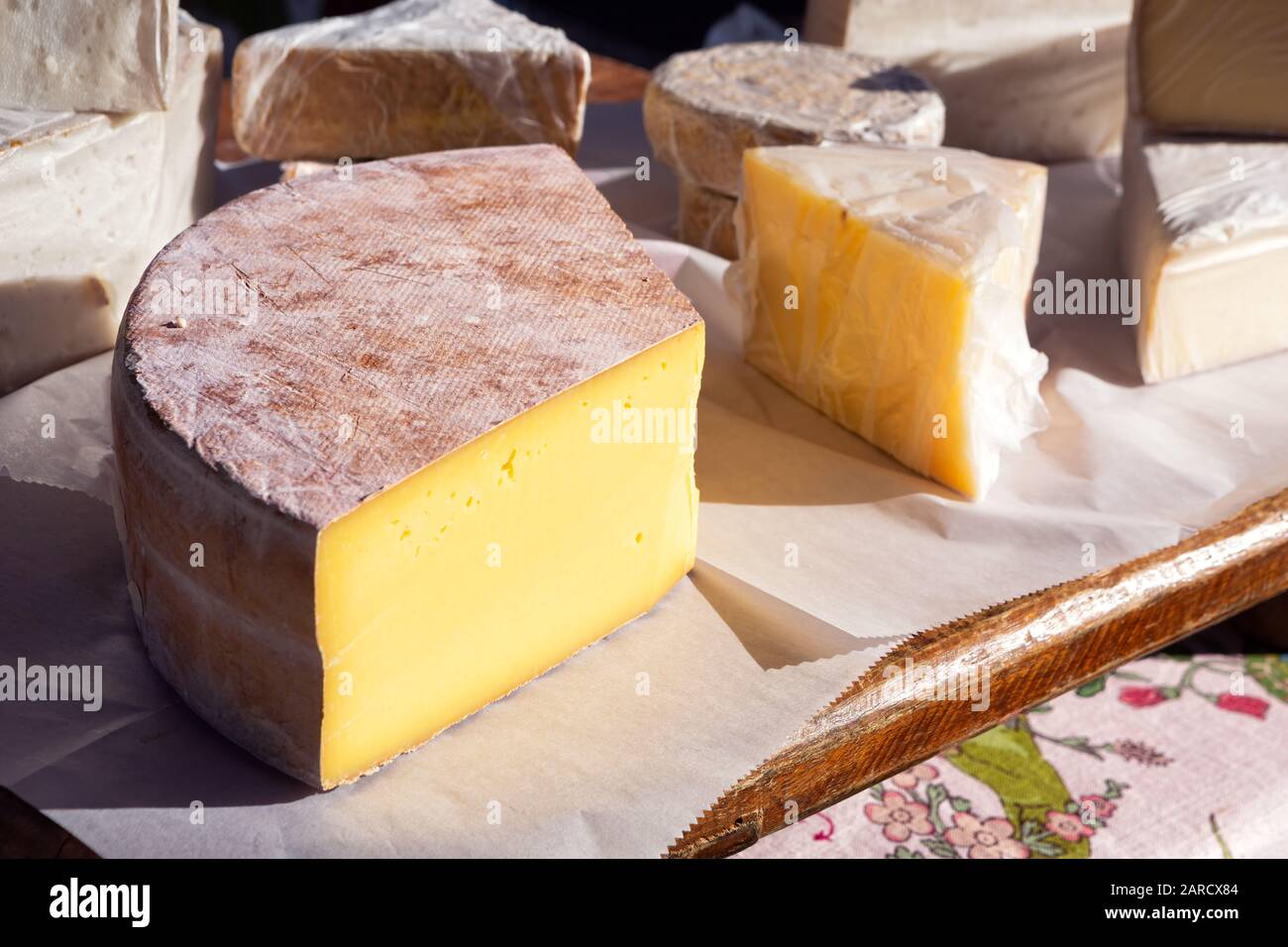 Large block of fresh European cheese at an outdoor market Stock Photo