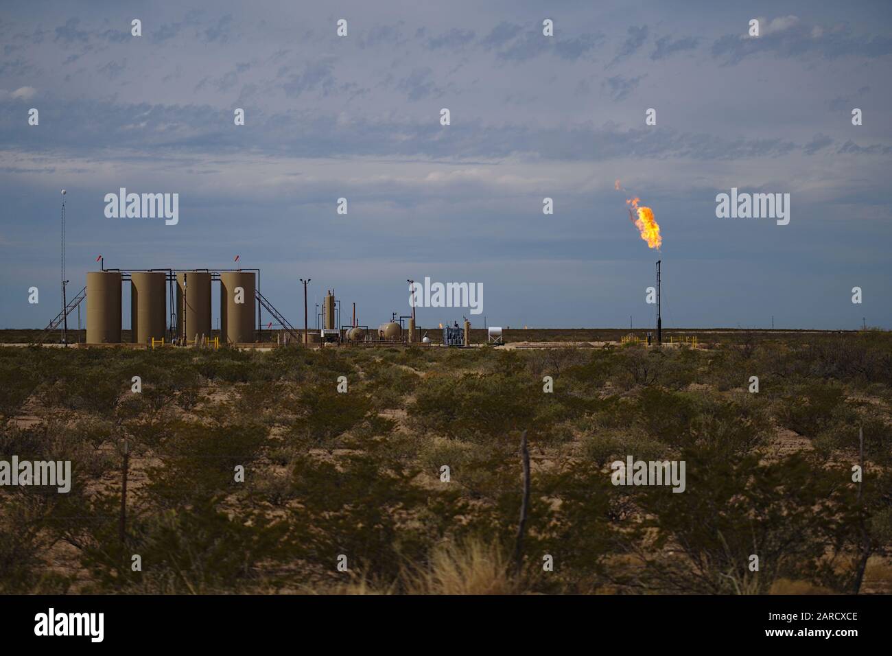 Permian Basin Gas Flare - Burning excess natural gas at a crude oil storage site is a common practice when gas prices deem it uneconomical. Stock Photo