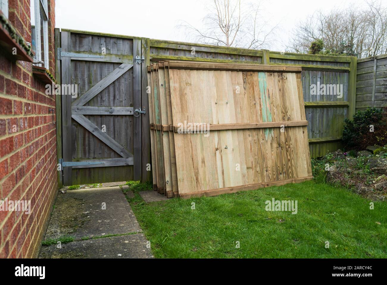 Replacement fence panels with vertical slats stacked waiting for