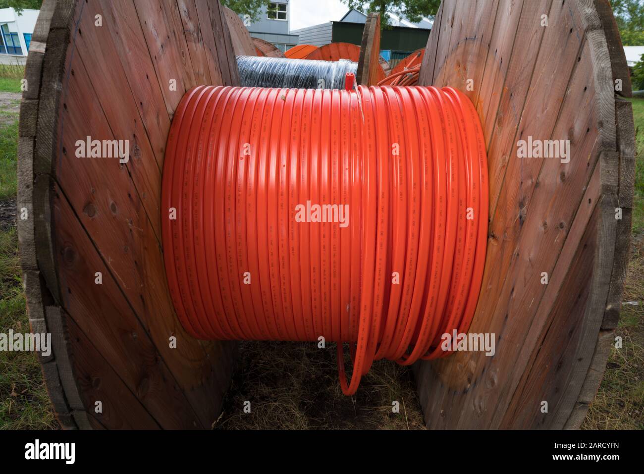 HENGELO, NETHERLANDS - AUGUST 25, 2018: closeup of a cable drum with orange fiber glass cable on a construction site Stock Photo