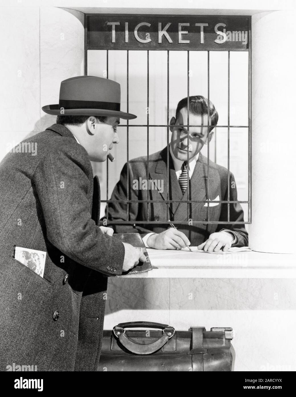 1930s 1940s 1950s MAN BUYING TICKET AT WINDOW IN BUS OR RAILROAD TRAIN STATION - asp x10847 CAM001 HARS RAILROAD TICKETS CLERK TICKET JOBS PASSENGER COPY SPACE HALF-LENGTH PERSONS MALES TRANSPORTATION B&W RUSH RAIL SUIT AND TIE OCCUPATION SELLING CUSTOMER SERVICE OVERCOAT EXCITEMENT CAM001 LABOR SELLER EMPLOYMENT OCCUPATIONS TRAVELING BUYER RAILROADS EMPLOYEE FARE OR PURCHASING MID-ADULT MID-ADULT MAN SALESMEN TRAVELER AGENT BLACK AND WHITE CAUCASIAN ETHNICITY HURRY LABORING OLD FASHIONED Stock Photo