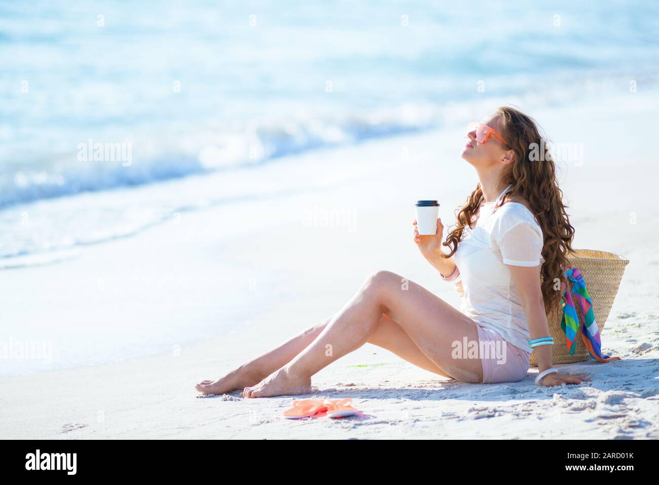 Woman drinking coffee beach hi-res stock photography and images