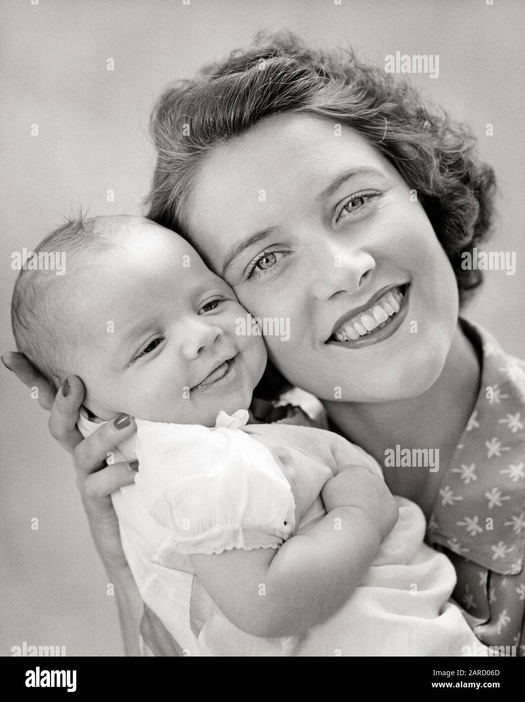 1940s PORTRAIT OF SMILING MOTHER LOOKING AT CAMERA HOLDING BABY DAUGHTER CHEEK TO CHEEK - b14414 HAR001 HARS OLD TIME FUTURE NOSTALGIA OLD FASHION 1 SILLY JUVENILE FACIAL YOUNG ADULT COMIC TEAMWORK INFANT PLEASED FAMILIES JOY LIFESTYLE SATISFACTION FEMALES RELATION STUDIO SHOT HEALTHINESS HOME LIFE COPY SPACE LADIES DAUGHTERS PERSONS CARING SPIRITUALITY EXPRESSIONS B&W EYE CONTACT HUMOROUS HAPPINESS HEAD AND SHOULDERS CHEERFUL AND COMICAL PRIDE RELATIONSHIPS SMILES CONNECTION COMEDY JOYFUL RELATED COOPERATION GROWTH JUVENILES MOMS TOGETHERNESS YOUNG ADULT WOMAN BABY GIRL BLACK AND WHITE Stock Photo