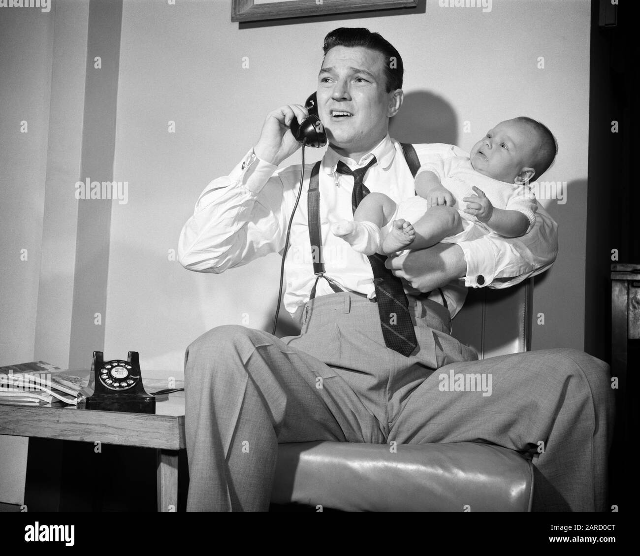 1950s DISTRESSED FATHER HOLDING BABY WHILE TALKING ON TELEPHONE - b807 DEB001 HARS PAIR SUBURBAN URBAN EMERGENCY RELATIONSHIP OLD TIME BUSY NOSTALGIA OLD FASHION 1 JUVENILE FEAR COMMUNICATION BALANCE TEAMWORK INFANT WORRY PANIC SONS LIFESTYLE PARENTING CALL RELATION HOME LIFE COPY SPACE FULL-LENGTH HALF-LENGTH PERSONS CARING CRY MALES AFRAID CALLING DIAPER FATHERS B&W CONCERNED SINGLE PARENT FATHERHOOD DADS EXCITEMENT STRESSFUL DIAPERS BAREFOOT CONCERN PHONES PEOPLE BABIES BUSINESS MAN TELEPHONES BOOTIE FEARFUL DEB001 BABY BOY BABY-SITTER BABY-SITTING BOOTY JUVENILES MID-ADULT MID-ADULT MAN Stock Photo