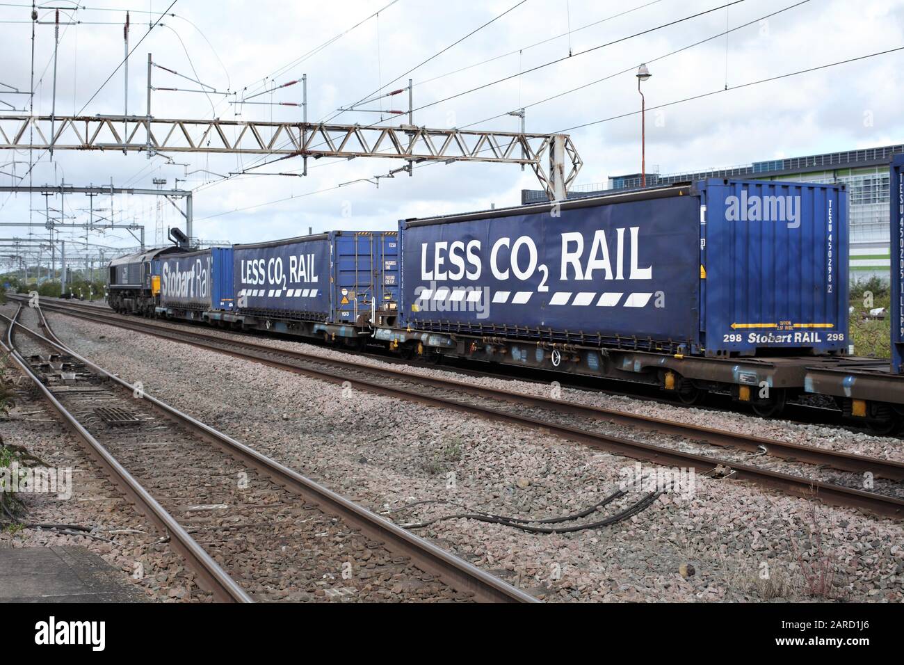 A train of freight containers publicising the environmental benefits of rail transport over road - 'LESS CO2...'. Stock Photo
