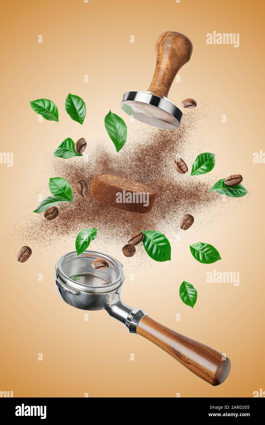 Exploded view of coffee holder and tamper with roasted beans and leaves Stock Photo