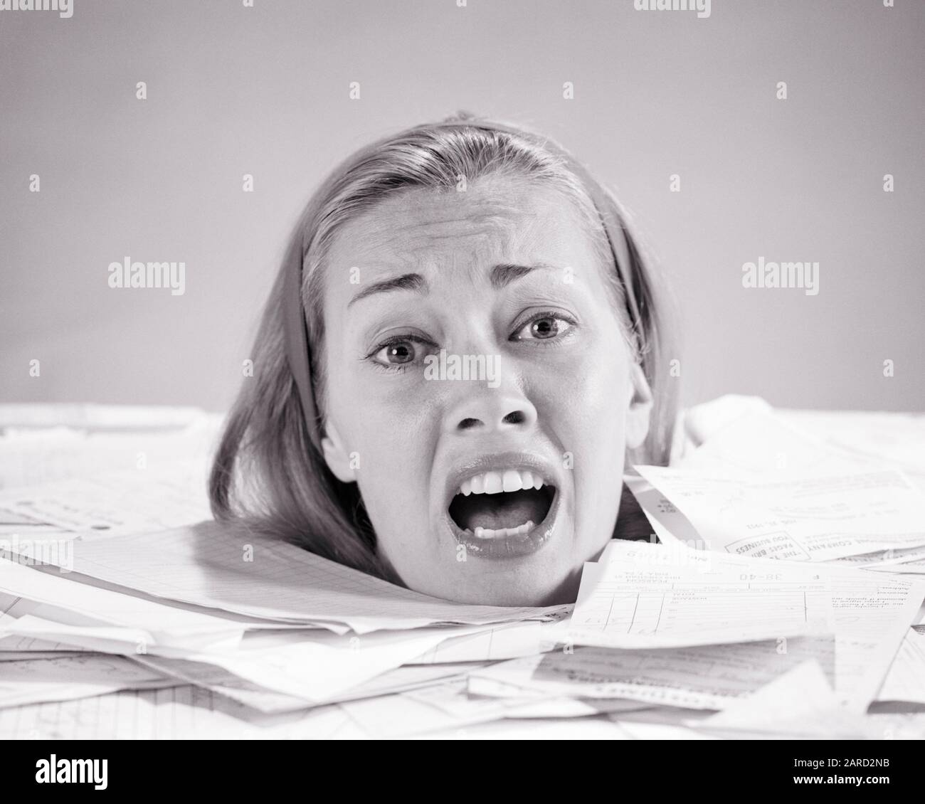 1960s WOMAN UP TO  HER NECK DROWNING IN PAPER BILLS INVOICES SHOUTING FOR HELP LOOKING AT CAMERA - s15445 HAR001 HARS NECK DEBT INFORMATION WORRY PROBLEM LIFESTYLE FEMALES STUDIO SHOT MOODY HOME LIFE FINANCES COPY SPACE LADIES PERSONS RISK AFRAID DROWNING EXPRESSIONS TROUBLED B&W CONCERNED FINANCIAL SADNESS EYE CONTACT HEAD AND SHOULDERS OVERWHELMED BANKRUPTCY UP MOOD CONCEPTUAL GLUM FEARFUL FRANTIC DEBTOR FAILURE MID-ADULT MID-ADULT WOMAN MISERABLE RUIN BLACK AND WHITE CAUCASIAN ETHNICITY DESPERATE HAR001 INVOICES OLD FASHIONED Stock Photo
