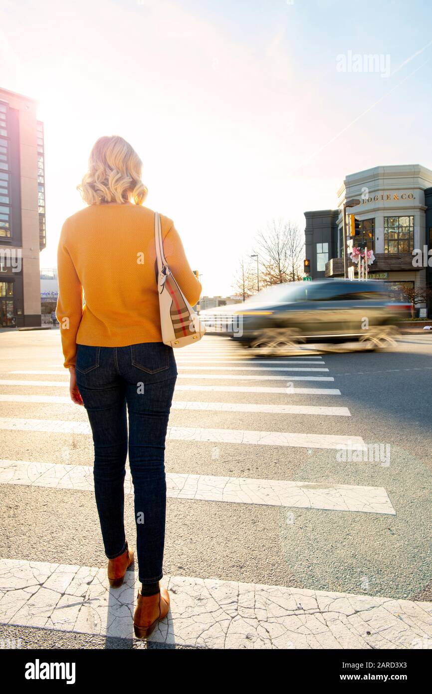 USA Maryland Bethesda Pedestrian safety woman crossing in a crosswalk with car traffic Stock Photo