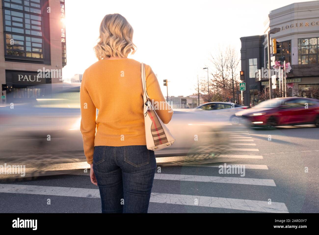 USA Maryland Bethesda Pedestrian safety woman crossing in a crosswalk with car traffic Stock Photo