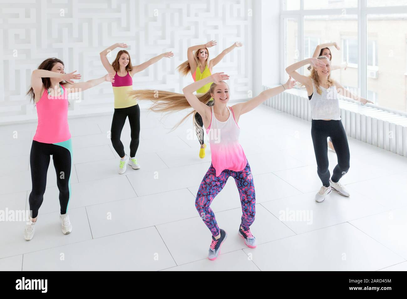 Young women in sportswear dancing with hands raised up at dance fitness  class Stock Photo - Alamy