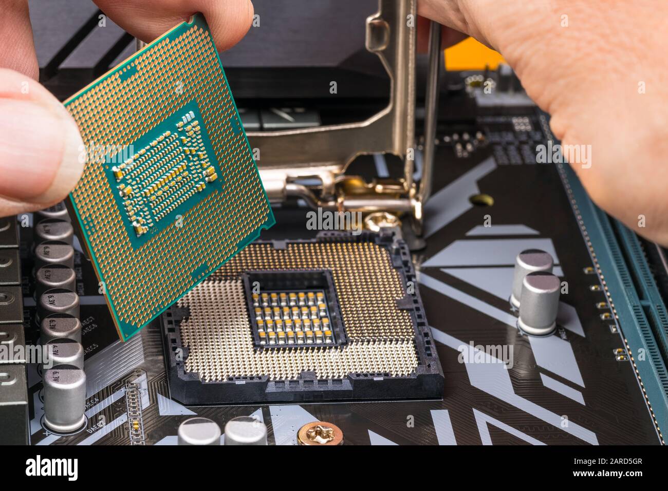 Computer processor maintenance detail. Hands installing microprocessor chip. Replacement of central processing unit in mainboard socket. Hardware part. Stock Photo