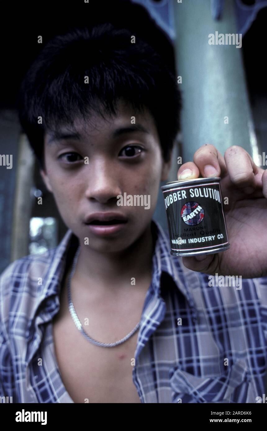 YOUNG MAN IN SINGAPORE GLUE SNIFFING. ALSO KNOWN AS BAGGING, GLADING, DUSTING OR HUFFING. Stock Photo