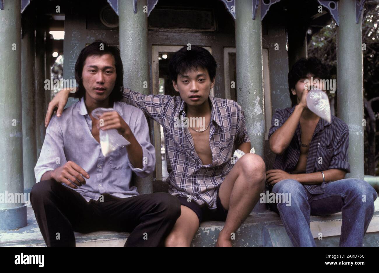 YOUNG MEN IN SINGAPORE GLUE SNIFFING. ALSO KNOWN AS BAGGING, GLADING, DUSTING OR HUFFING. Stock Photo