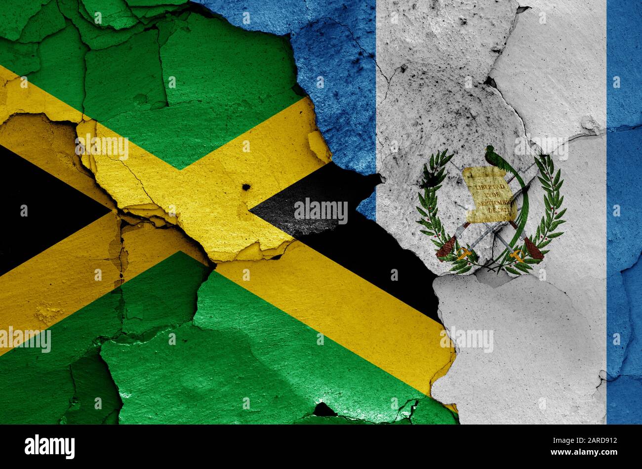 flags of Jamaica and Guatemala painted on cracked wall Stock Photo