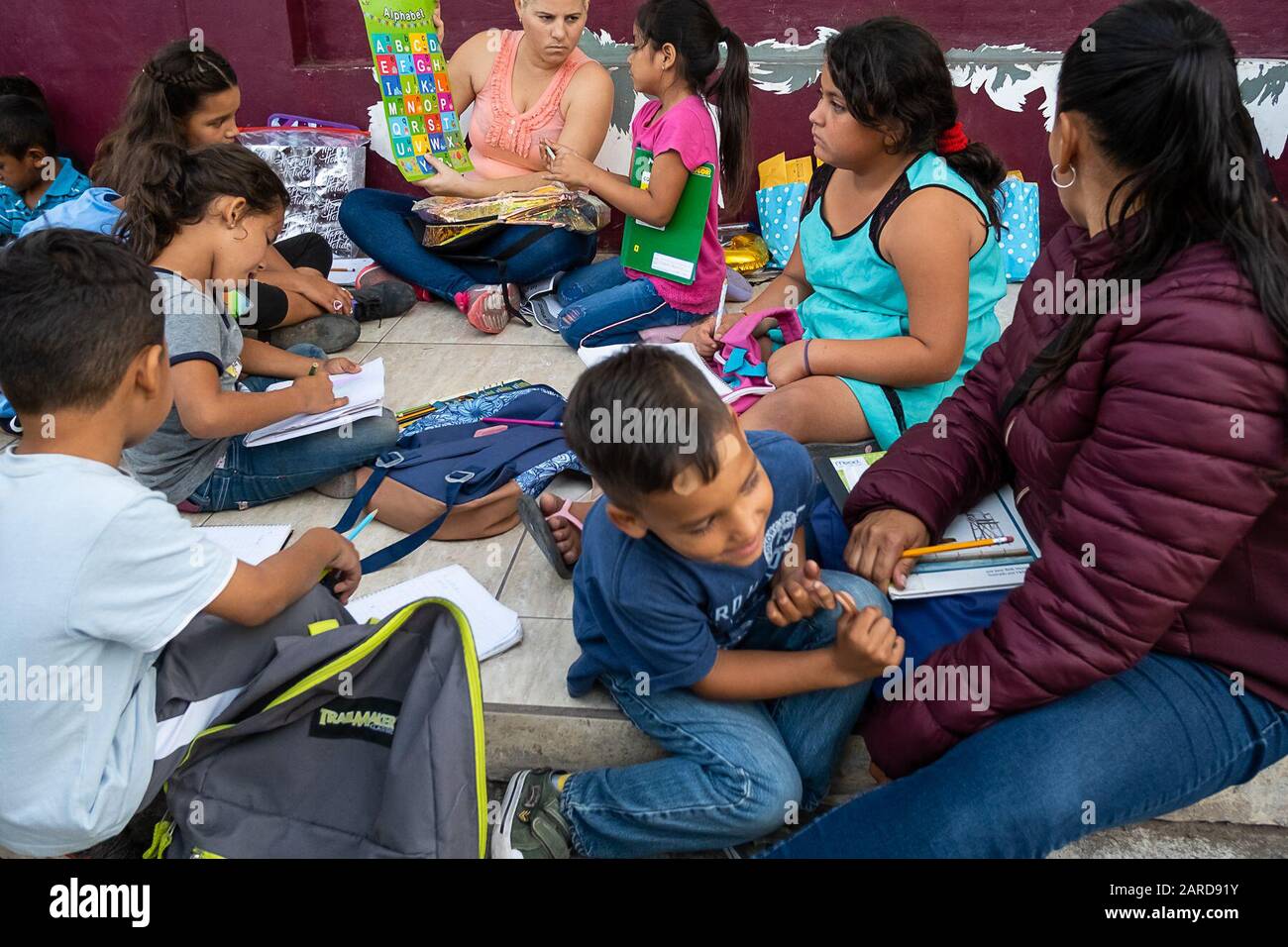 Children seeking asylum who are living in a tent city in Matamoros, Mexico, attend a sidewalk school. The school was organized by Felicia Rangel-Samponaro used to be a teacher in Houston, Texas. The sidewalk school employs asylum seekers as teachers. Stock Photo