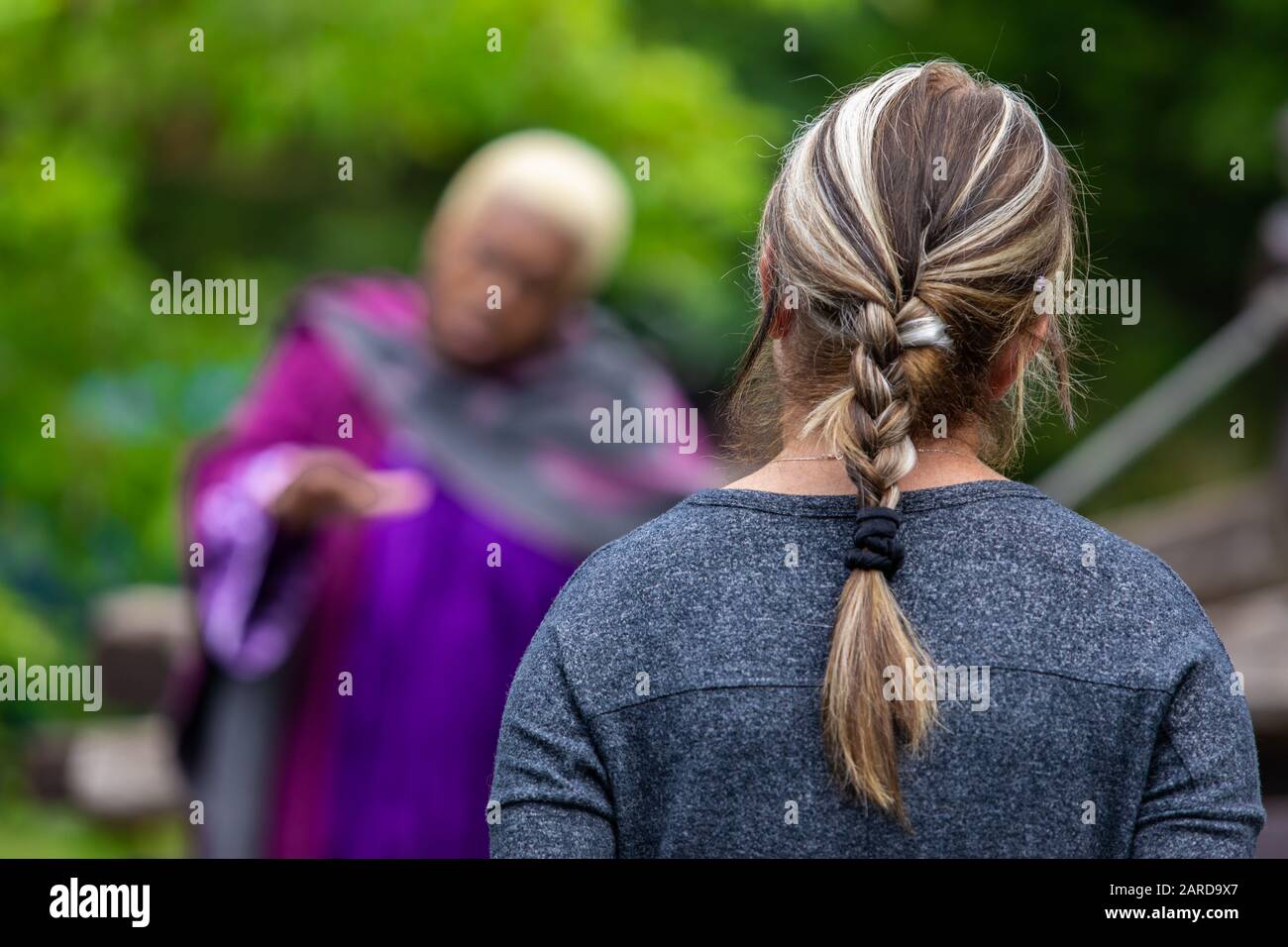 Closeup Rear View Of Woman With Tied Braided Hair While Listening