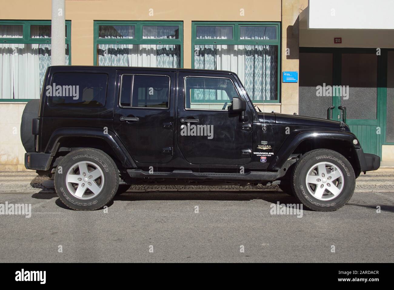 Faro, Portugal - December 28, 2019: Black Wrangler Sahara Unlimited parked b y the side of the road. Nobody in the vehicle. Stock Photo